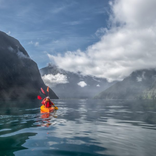 Two people kayaking in Milford Sound, New Zealand.